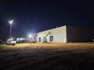 Enclosed data center support building under light towers at night
