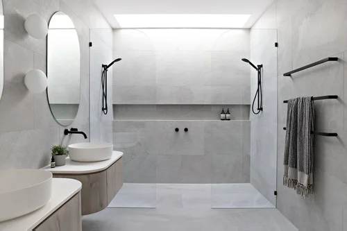 Completed bathroom with twin basins and a wide frameless shower