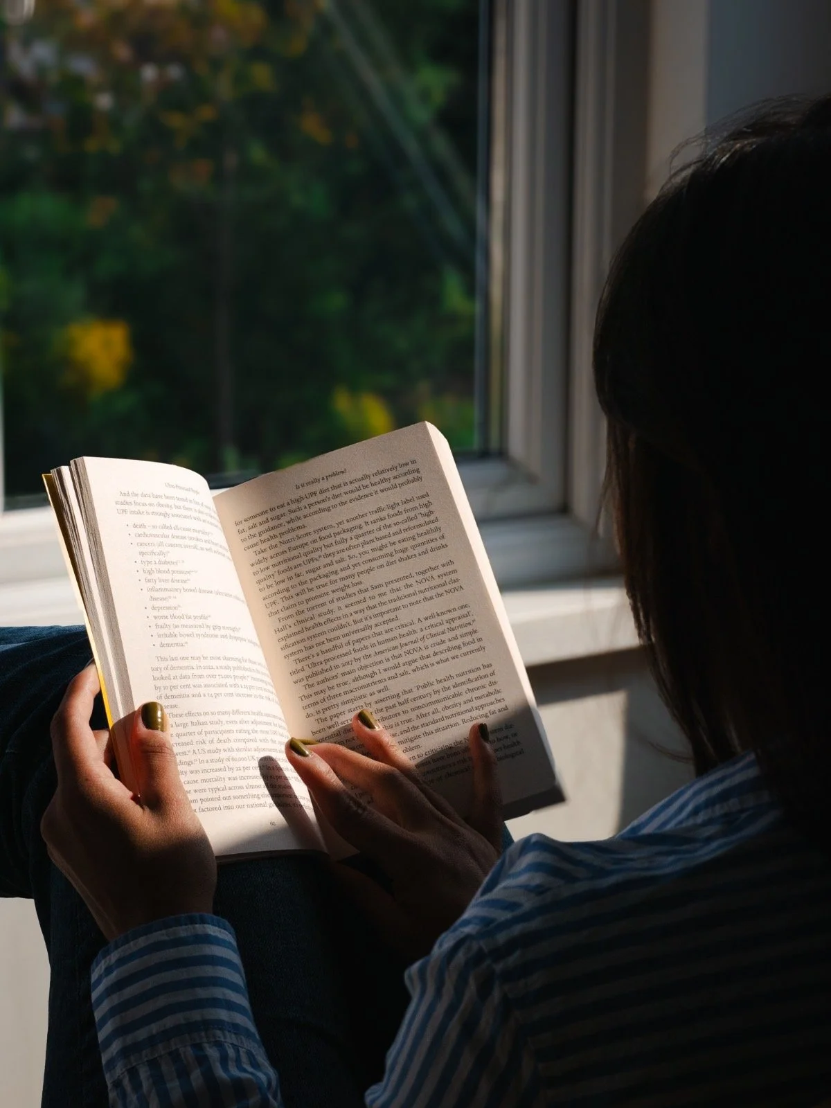 person reflecting by a window during emotional adjustment while living abroad