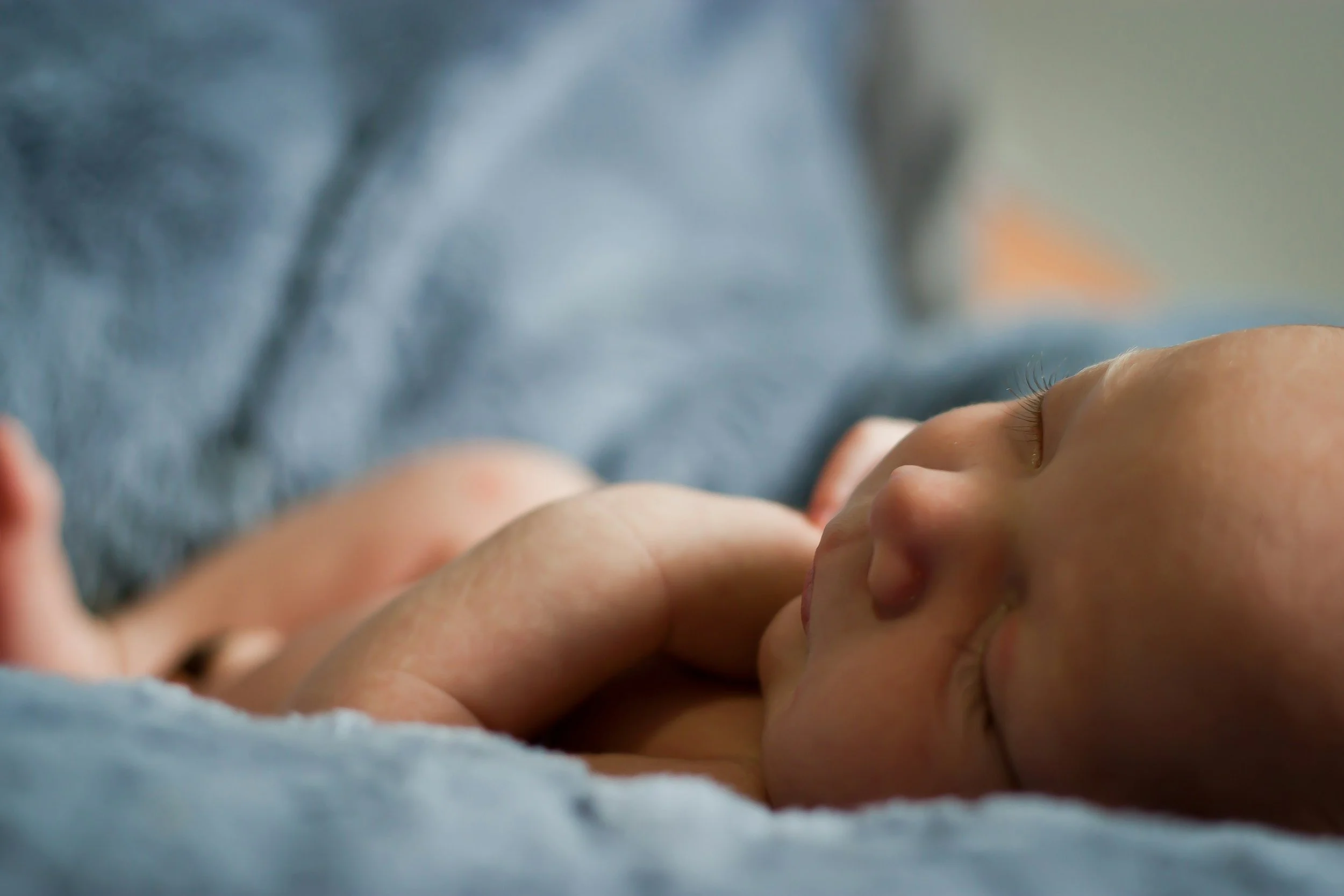 Sleeping newborn baby on soft blue blanket
