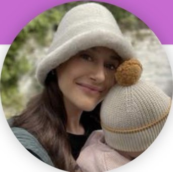 Woman wearing hat smiling next to child with hat outdoors