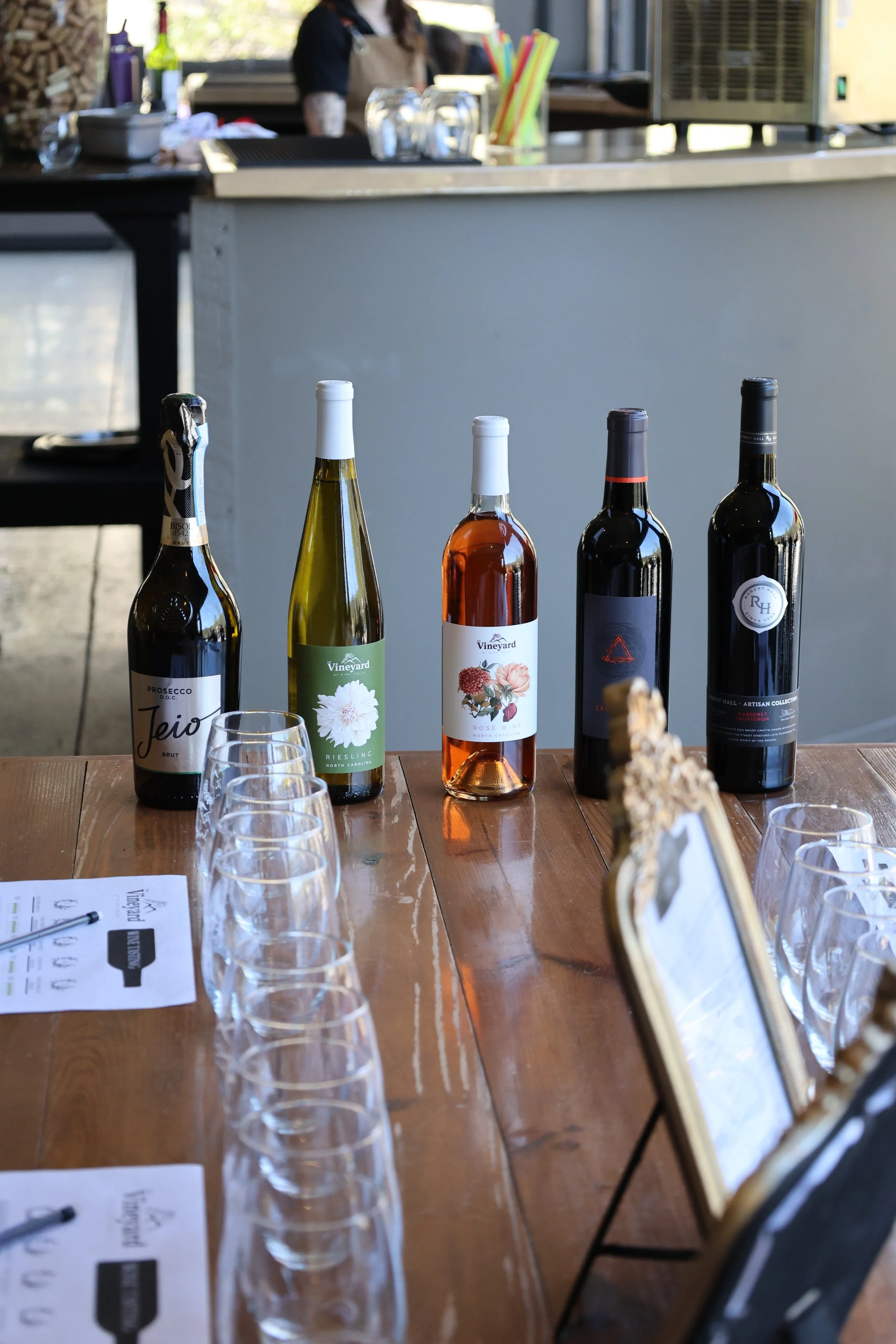 A selection of five bottles of estate-grown red, white, and rosé wines lined up for a professional wine tasting session.