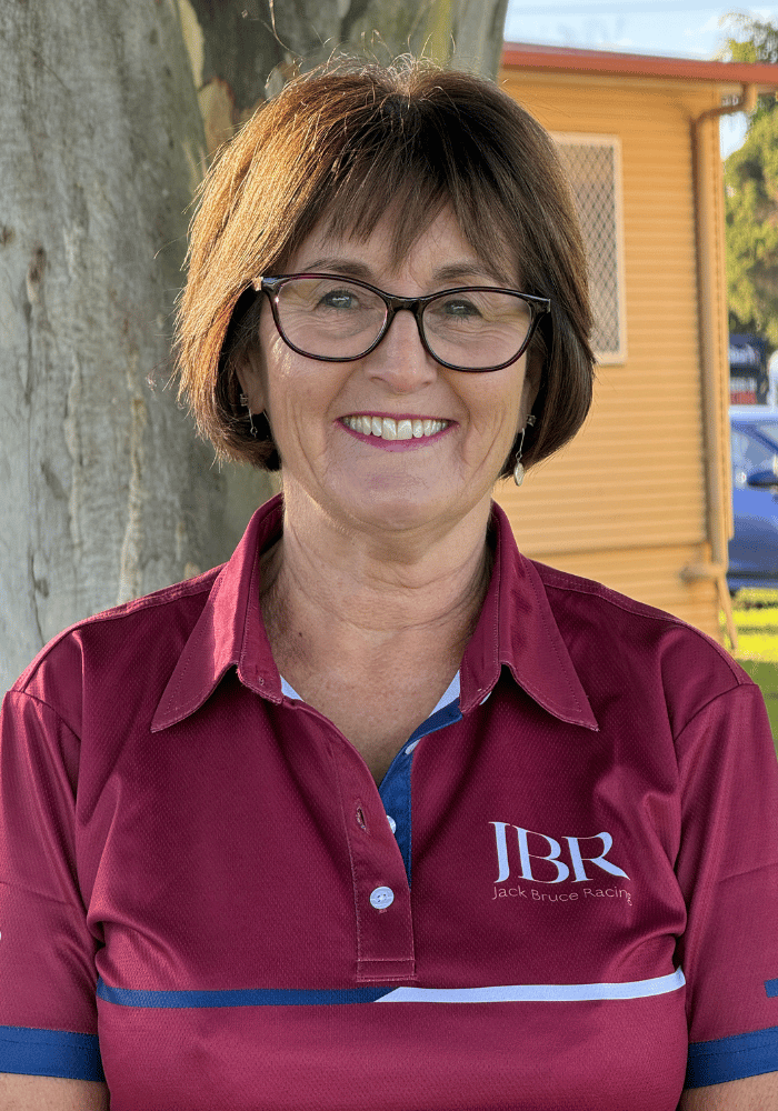 Portrait photo of an older lady with brown short hair wearing a maroon polo with JBR on the chest