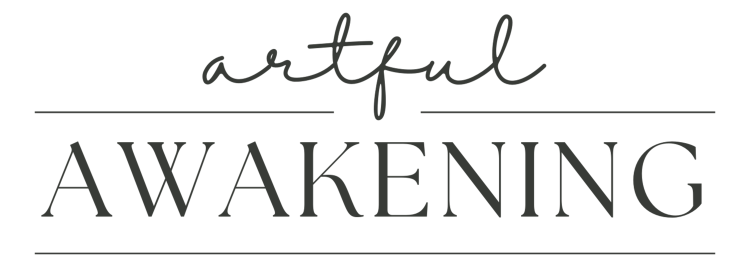 The image displays the phrase 'artful awakening' with 'artful' written in a cursive, gray font above the word 'awakening,' which is in a bold, uppercase, black font, separated by two horizontal lines.