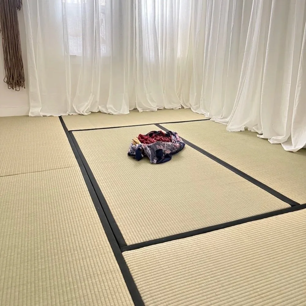 A leg in black tights tied in stylish red rope