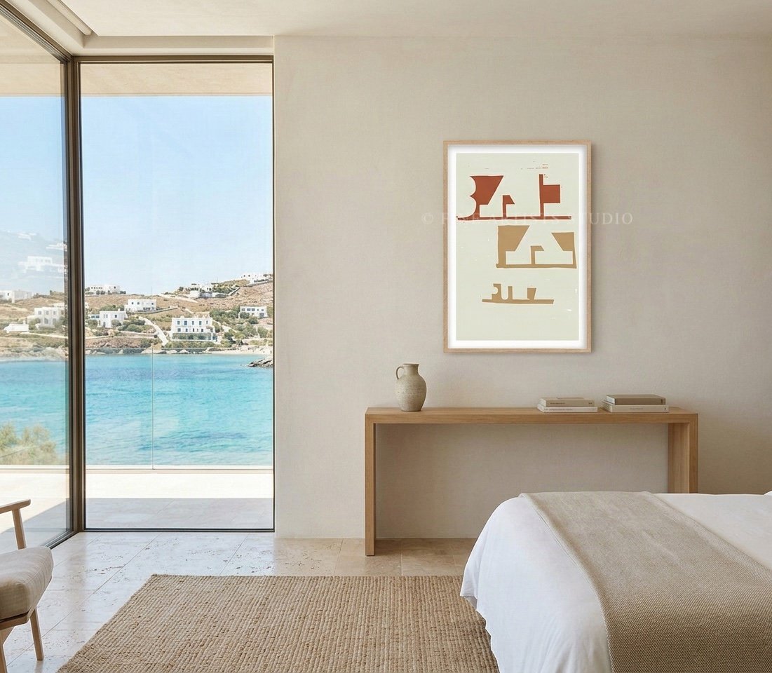 Vertical abstract fine art print hanging in a bright, luxury minimalist bedroom overlooking the turquoise sea and white hillside houses of a Greek island.