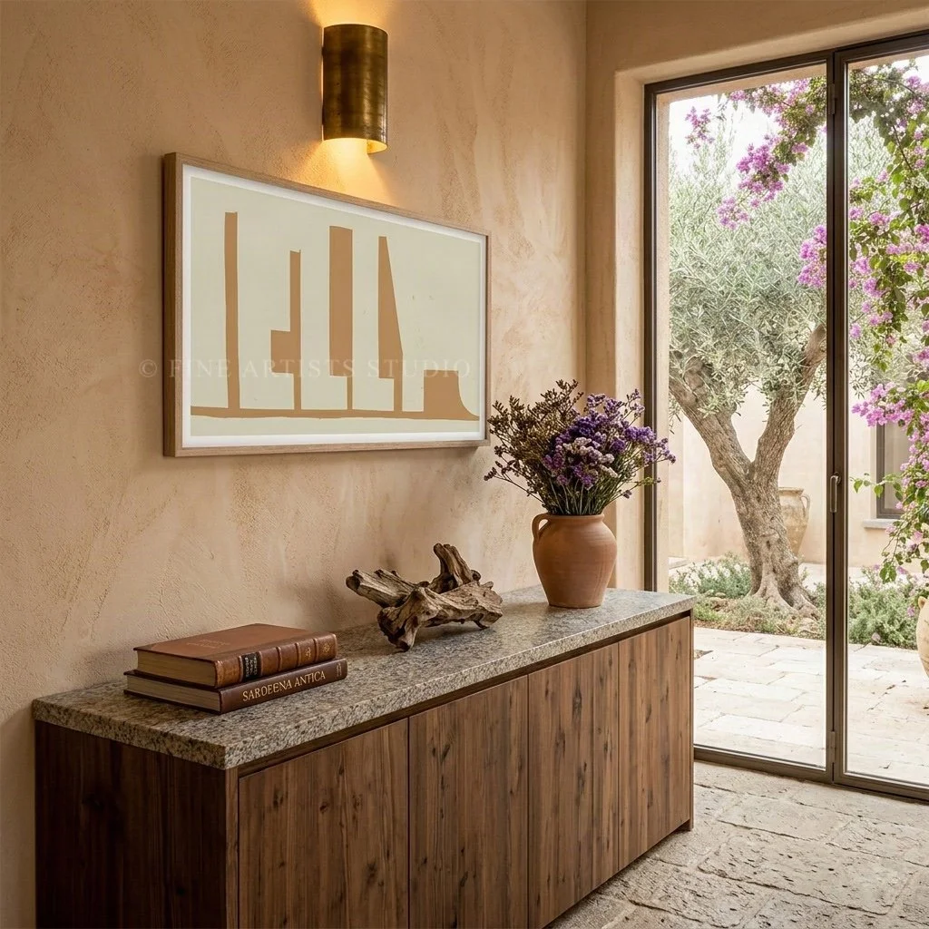Modern horizontal art print styled on a sandy plaster wall beside a structural concrete column, accented by organic window plant shadows.