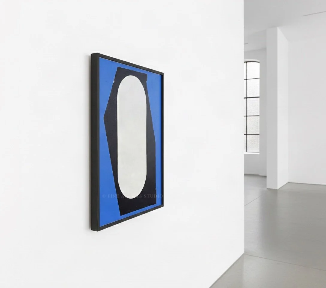 Angled perspective view of the framed blue, black, and white abstract artwork "Signal II" showcasing the clean lines of its dark frame on a gallery wall.