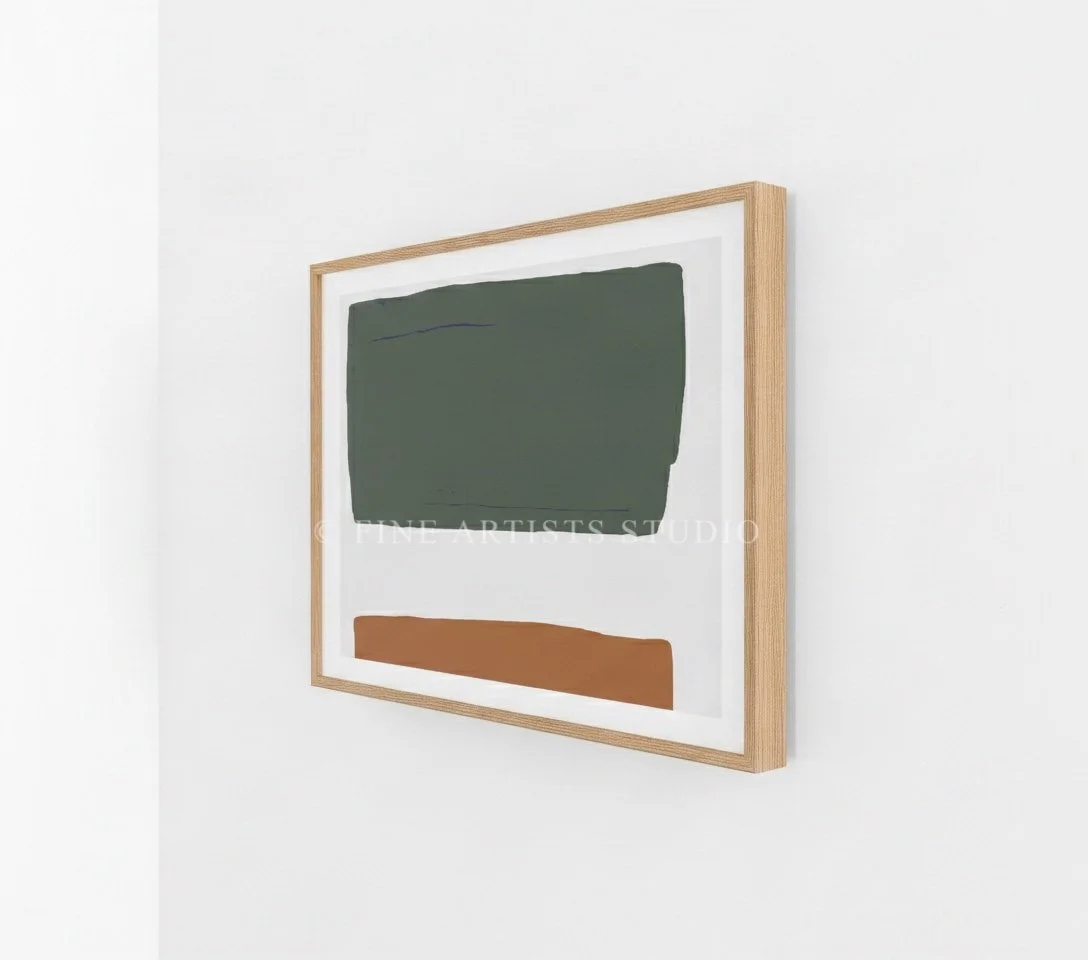 Close-up angled shot of a framed abstract print showcasing clean moss green and dark brown geometric art block shapes.
