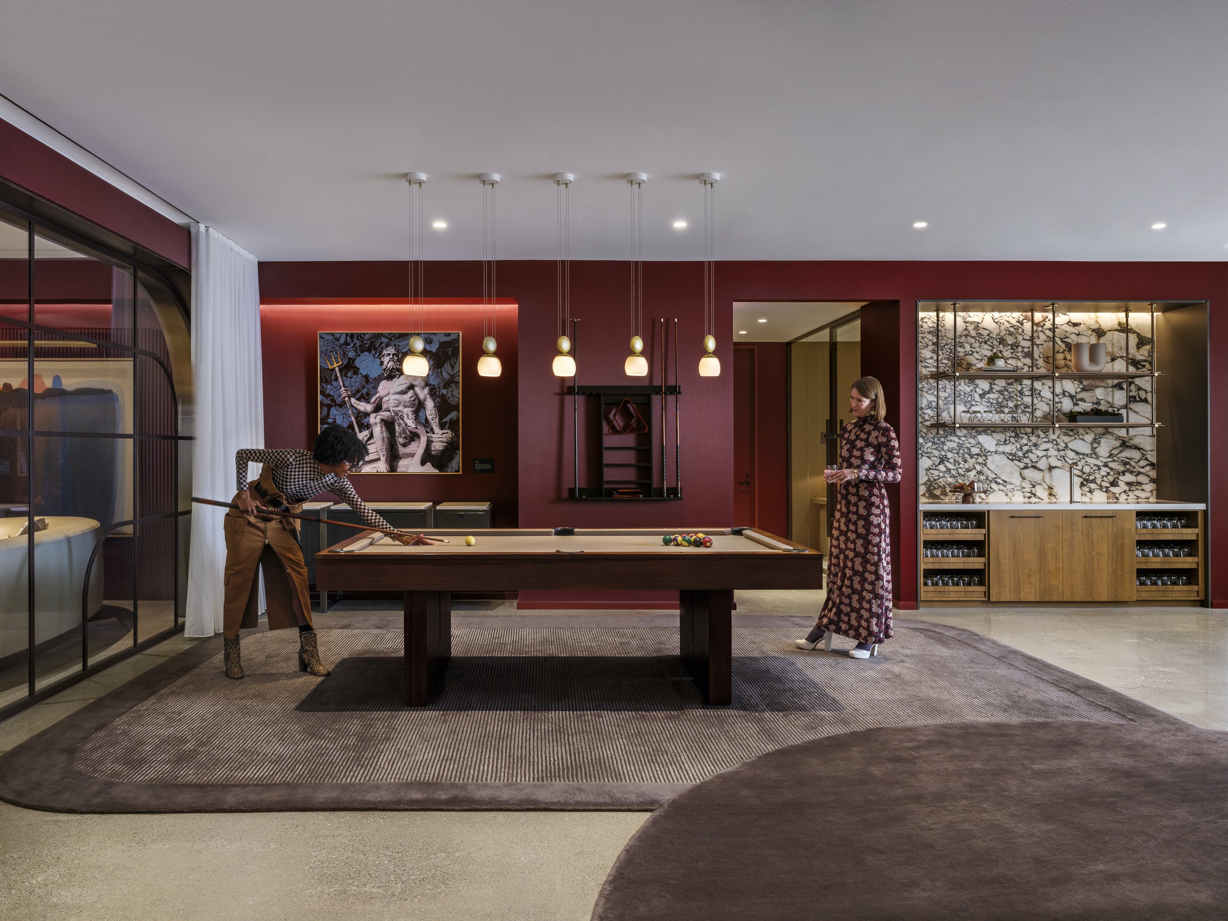 Recreation room designed by genteel pool table with two women dressed up for the night 