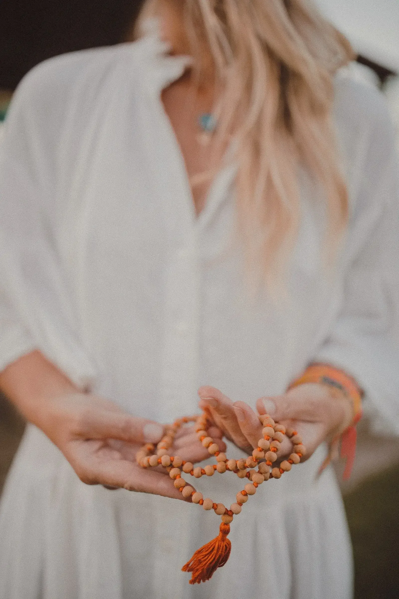 Lindsay holding a mala bead necklace