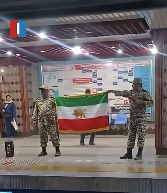 Teheran | Het hijsen van de leeuw-en-zonvlag in het metrostation Imam Khomeini door twee militairen