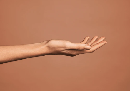 Extended hand with palm facing upward against a neutral background.