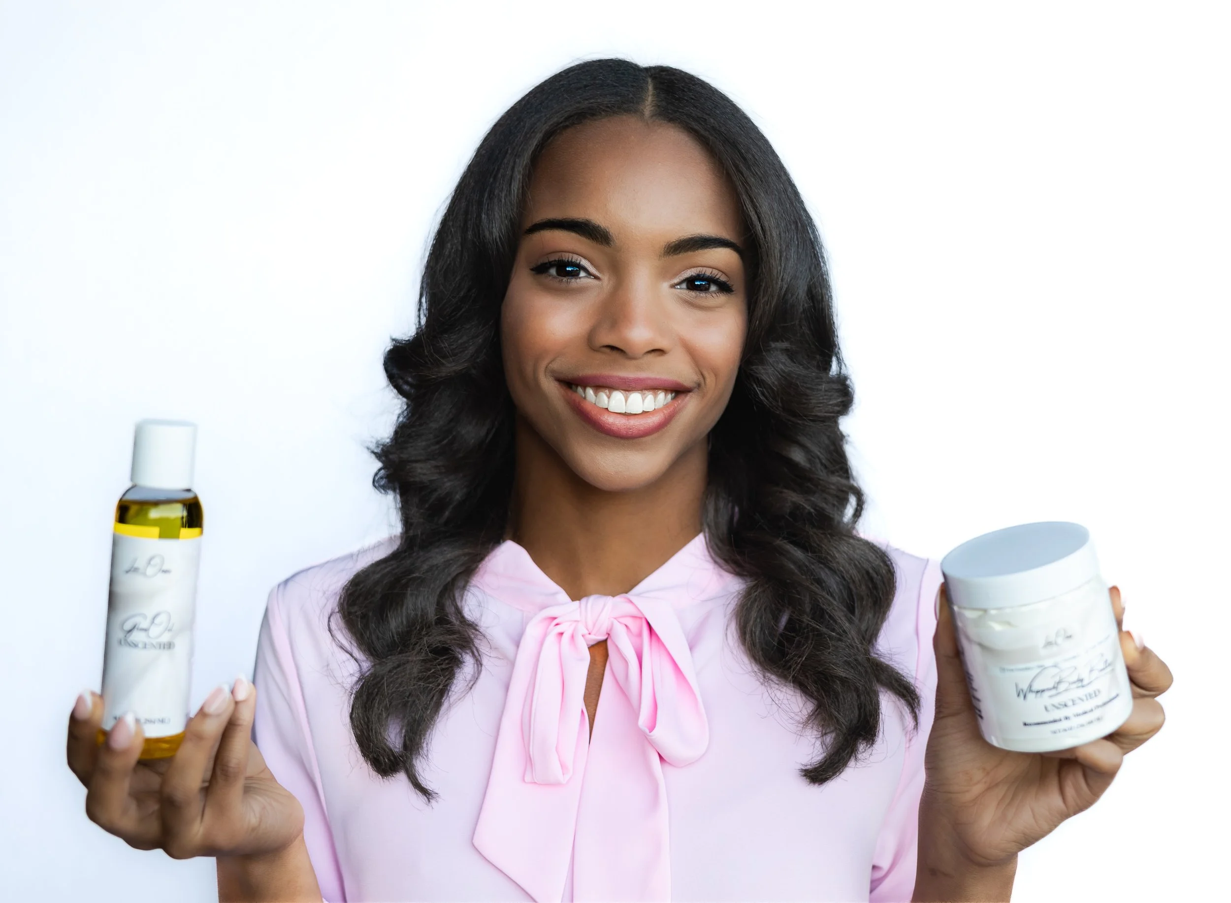 Lux Oasis Founder and CEO Zaria Parker holding an unscented glow oil and whipped body butter