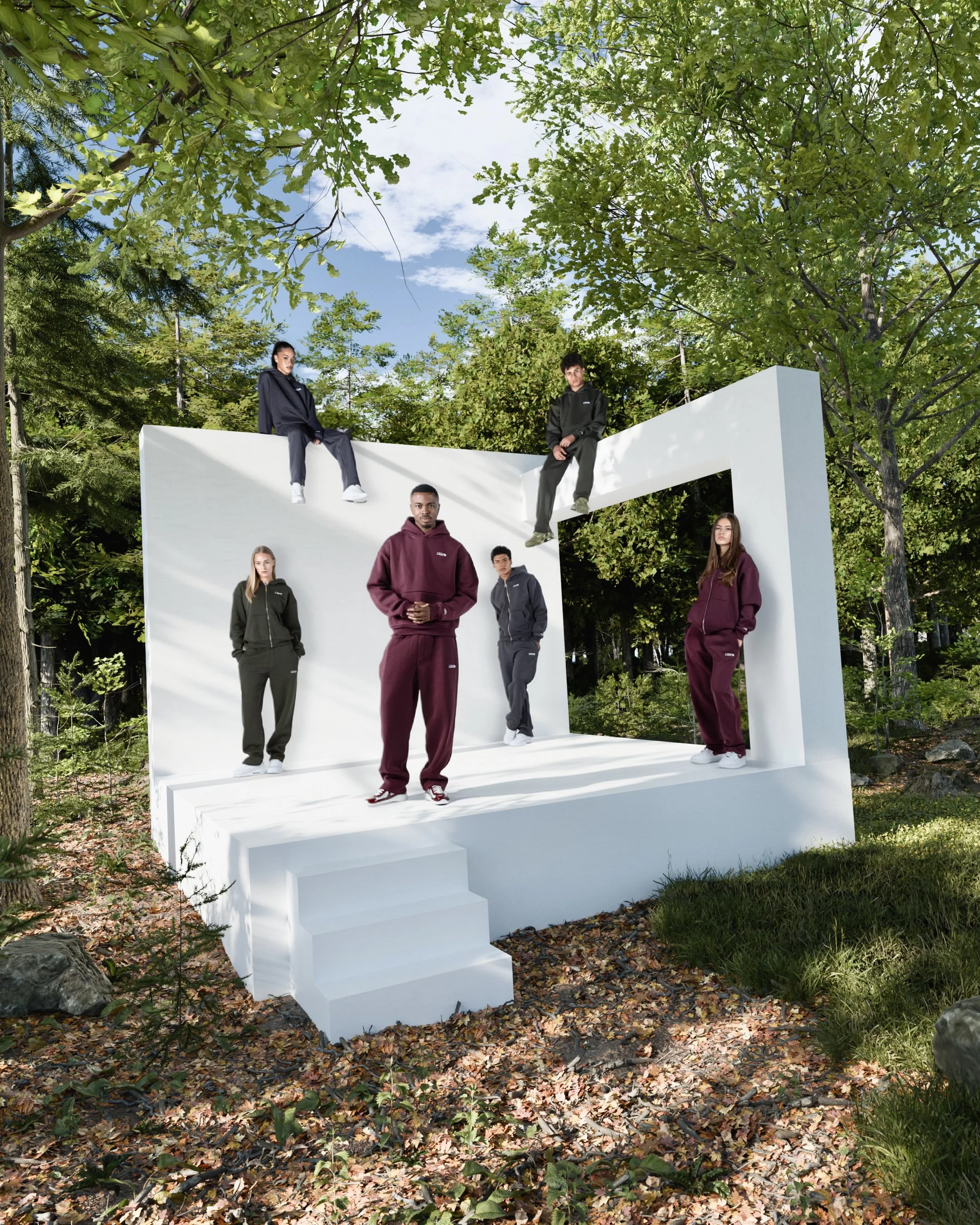 Menschen in CUSB Streetwear posieren auf einer weißen Plattform im Freien, umgeben von grünen Bäumen.