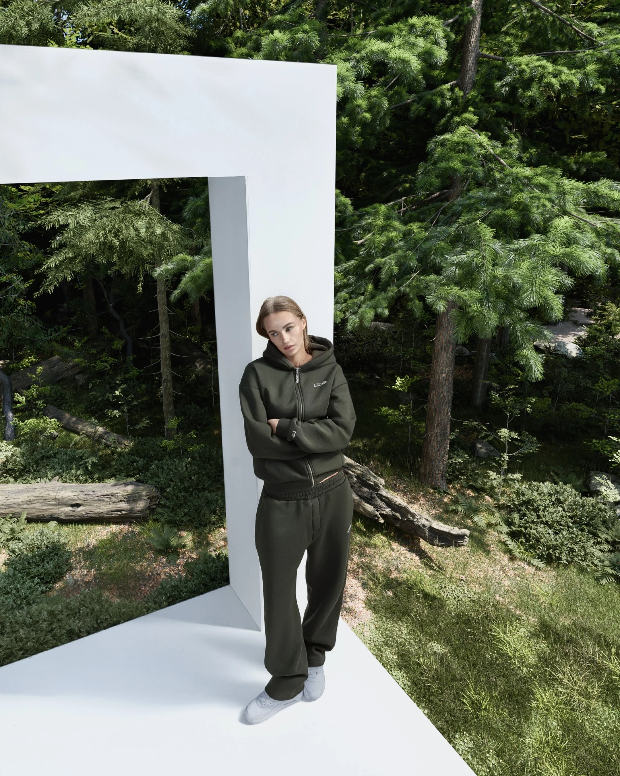 Ebba Moberg in CUSB dunkler Joggingbekleidung steht vor einer weißen Kulisse mit grünen Bäumen im Hintergrund.