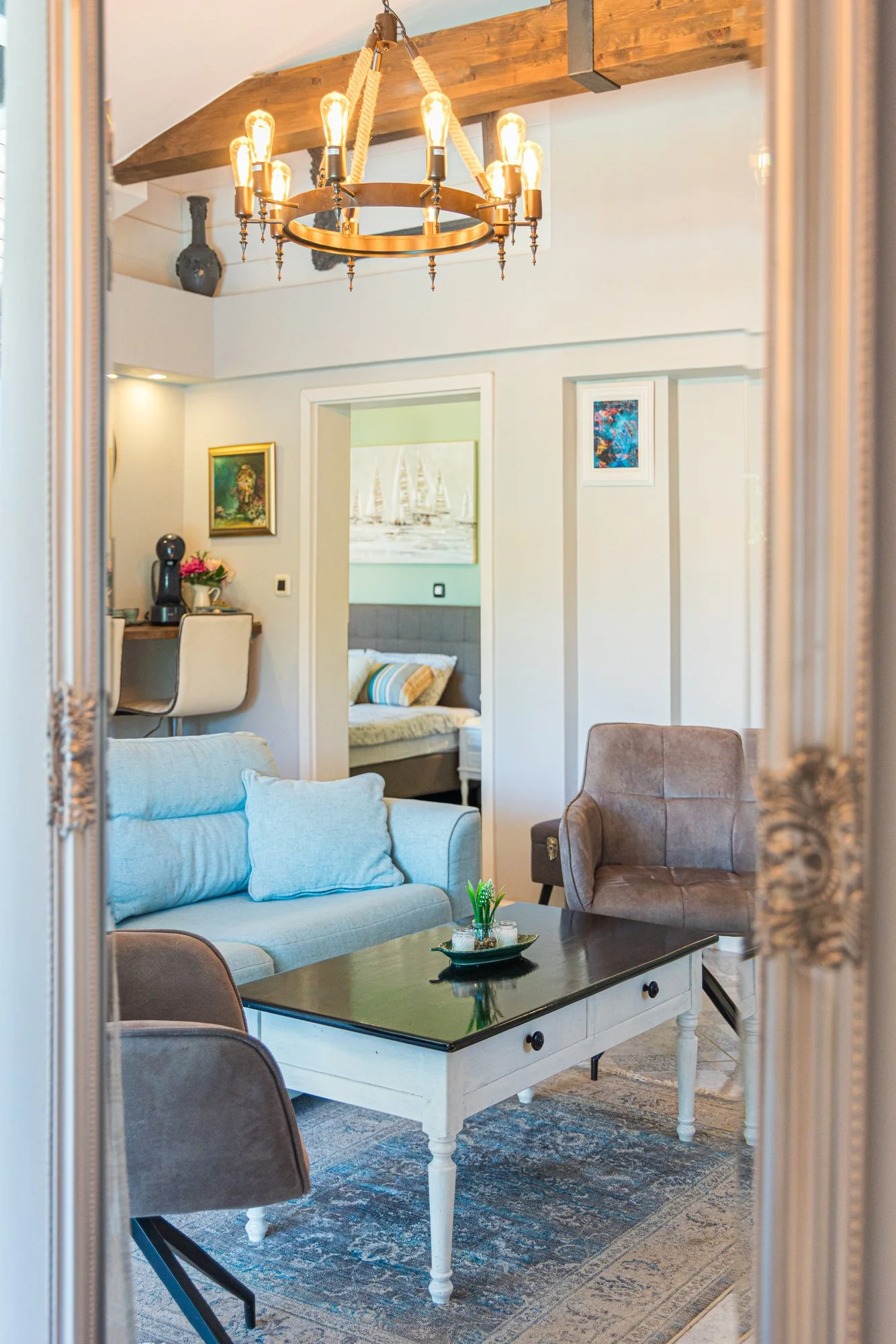 Cozy living space with chandelier and rustic wooden beam in a luxury holiday home