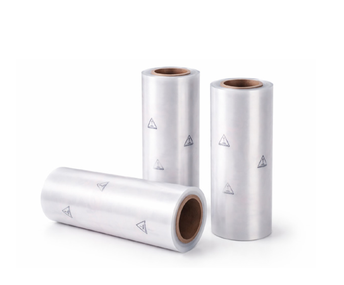Three large rolls of transparent stretch film, with silver color and small black triangle markings, on a white background.