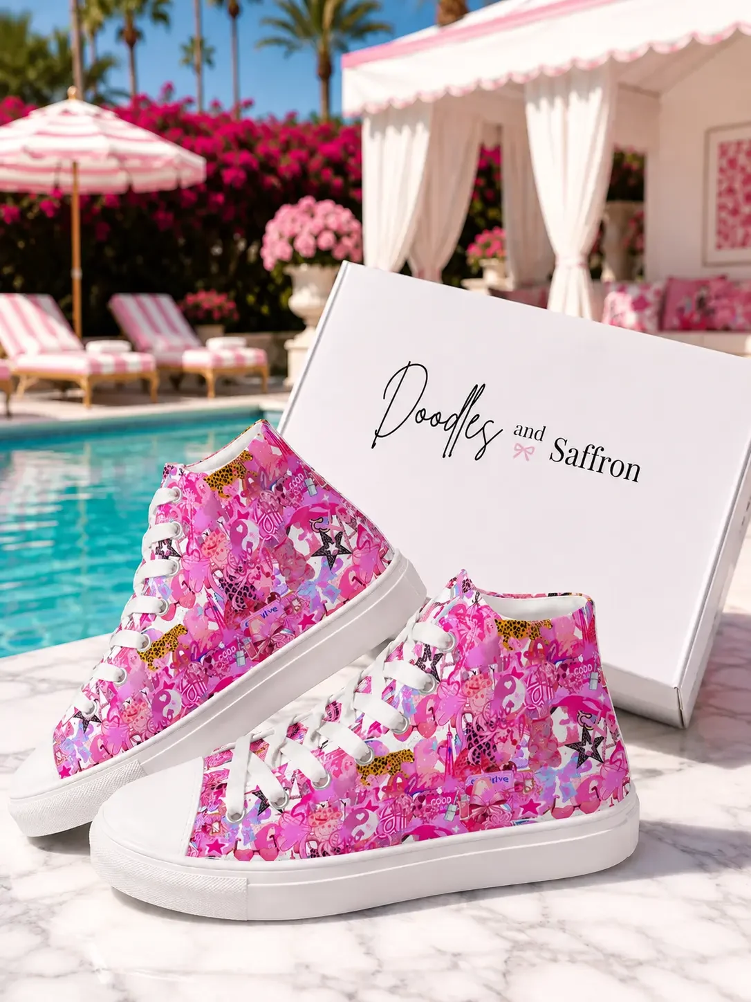 Pair of bright pink graffiti print canvas high-top sneakers standing in front of a white retail shipping box by a pool.