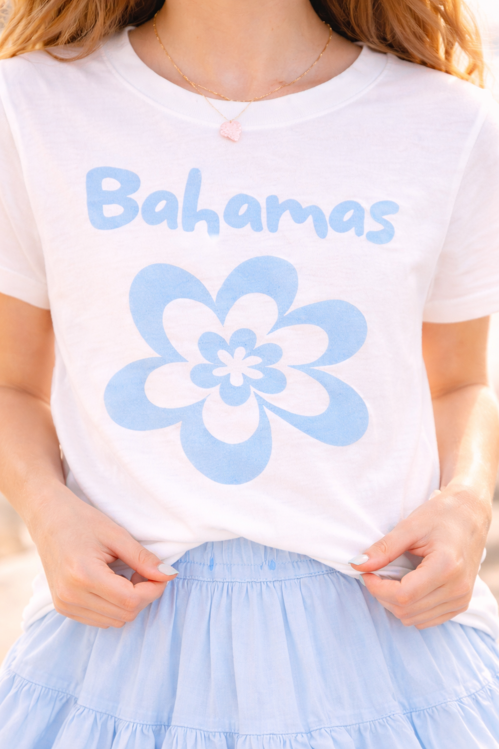 Close-up of white Bahamas flower graphic t-shirt with light blue floral design.