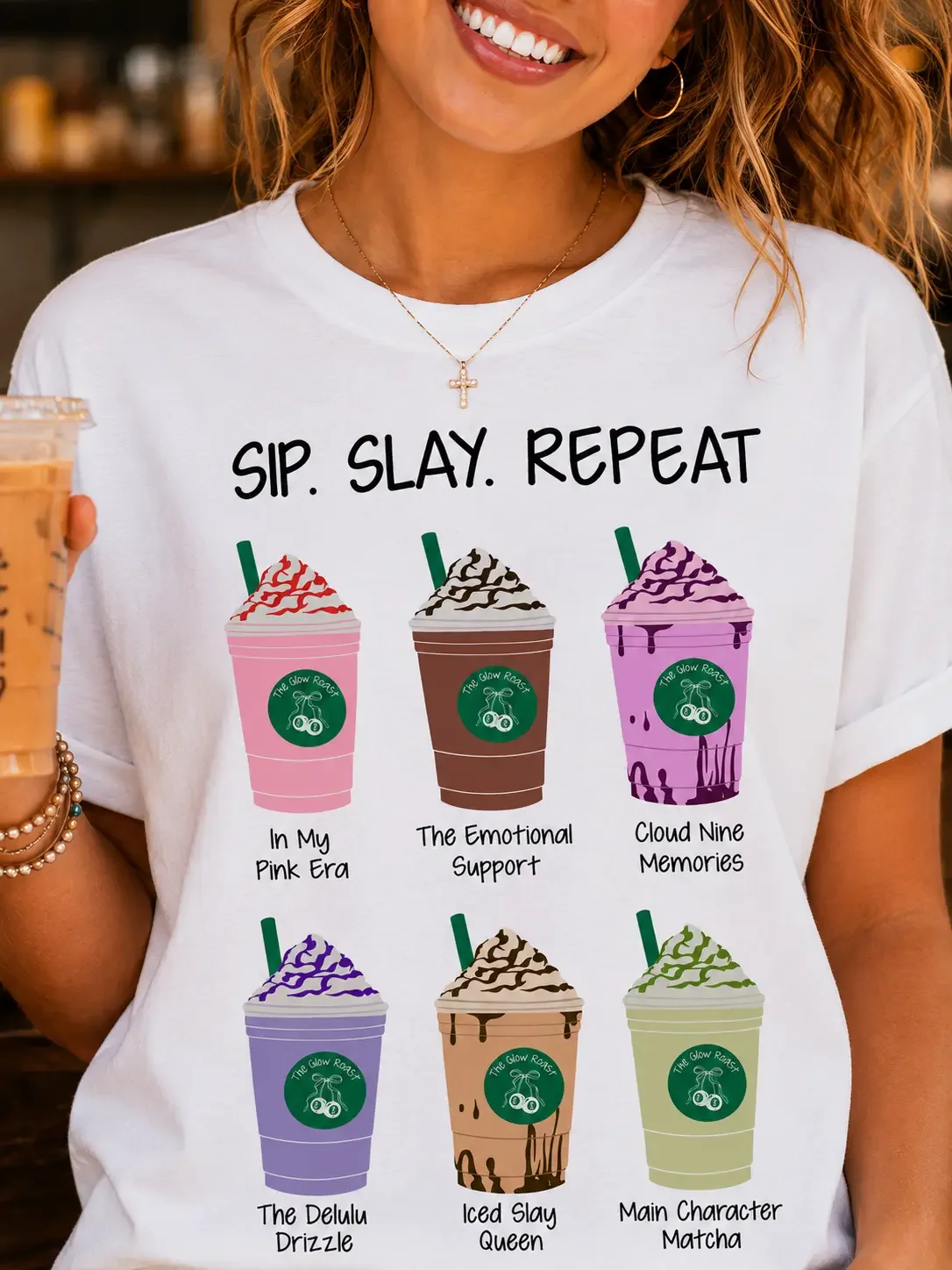 Close-up of a woman wearing a white t-shirt featuring a "Sip. Slay. Repeat." graphic with six labeled iced coffee cups.