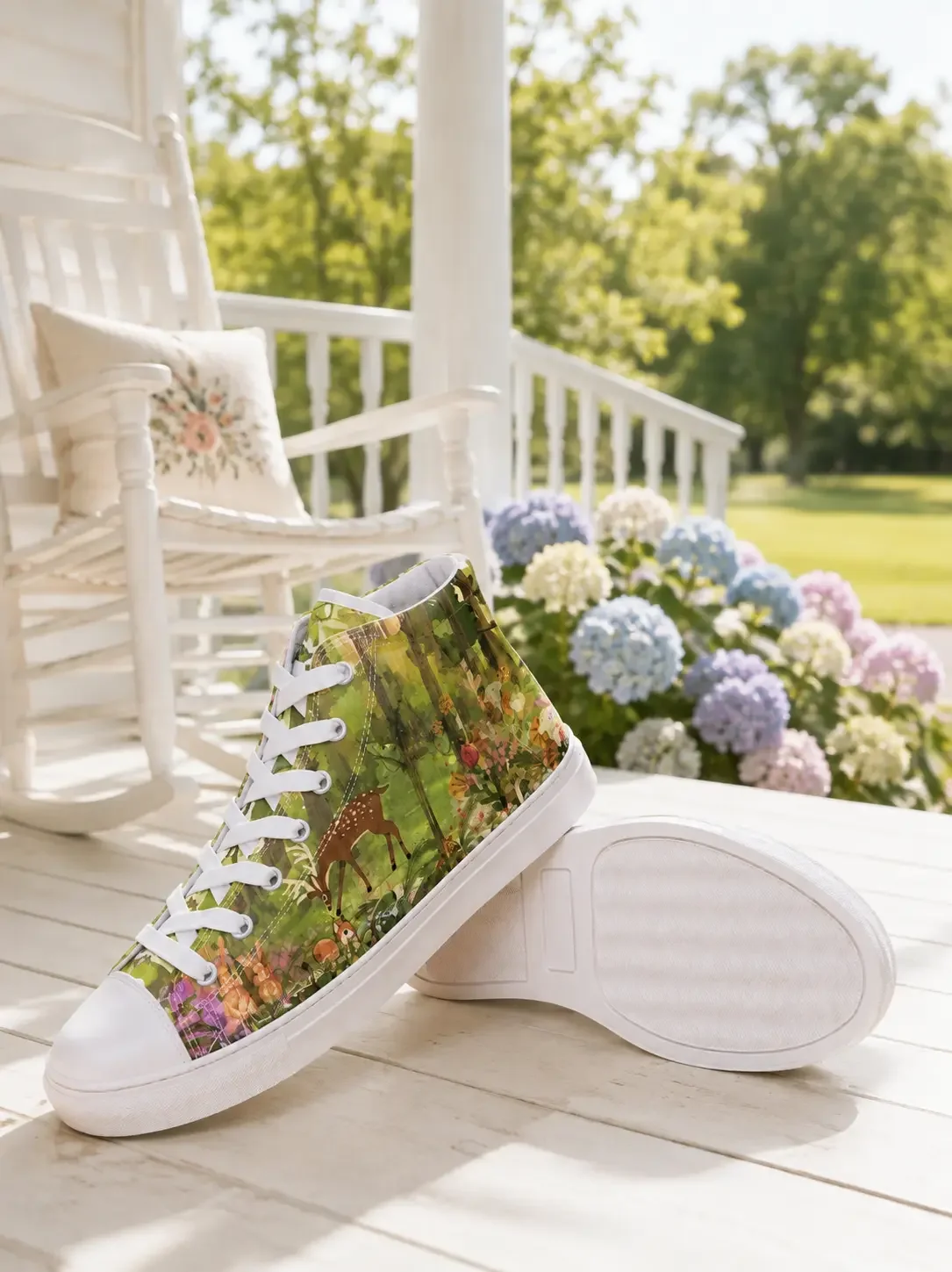 A forest woodland print high-top canvas sneaker featuring a deer illustration displayed on a bright porch with a white rocking chair and blooming hydrangeas.
