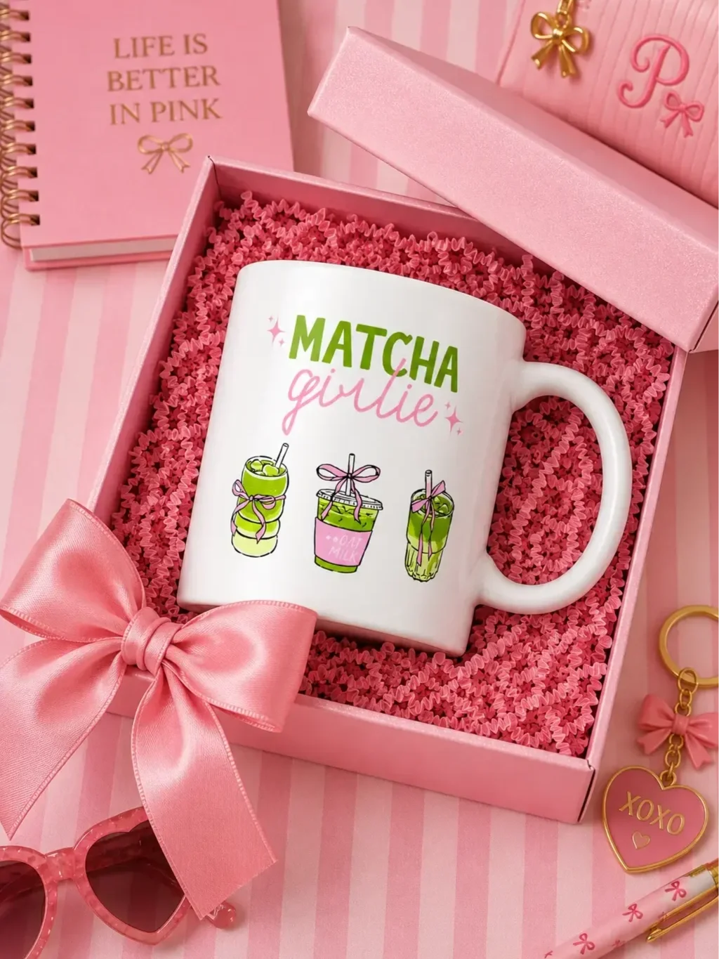 White Matcha Girlie ceramic mug nestled in an opened pink gift box with a satin bow, surrounded by matching stationery.
