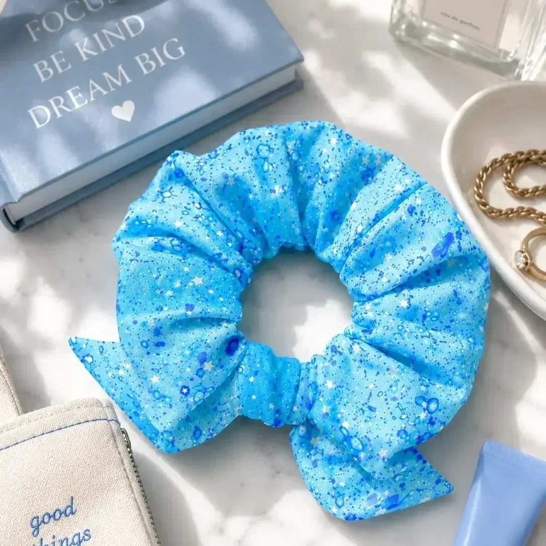 preppy-girl-blue-star-pattern-bow-scrunchie-close-up.webp