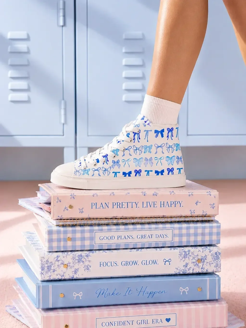 blue-coquette-bow-canvas-sneakers-stacked-notebooks-view.webp