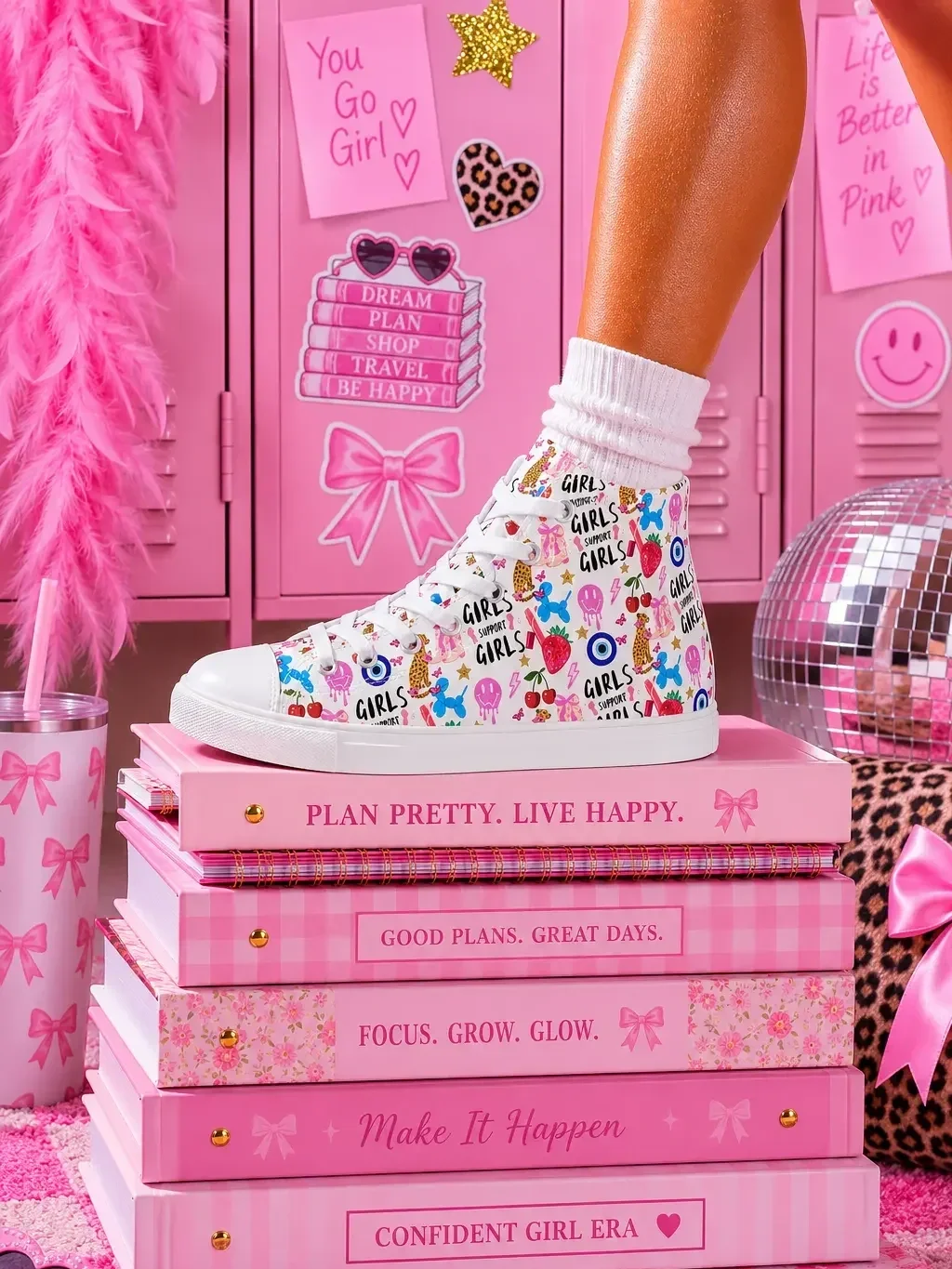 A person wearing white graphic high-top canvas sneakers standing on top of a stack of pink preppy journals by pink school lockers.
