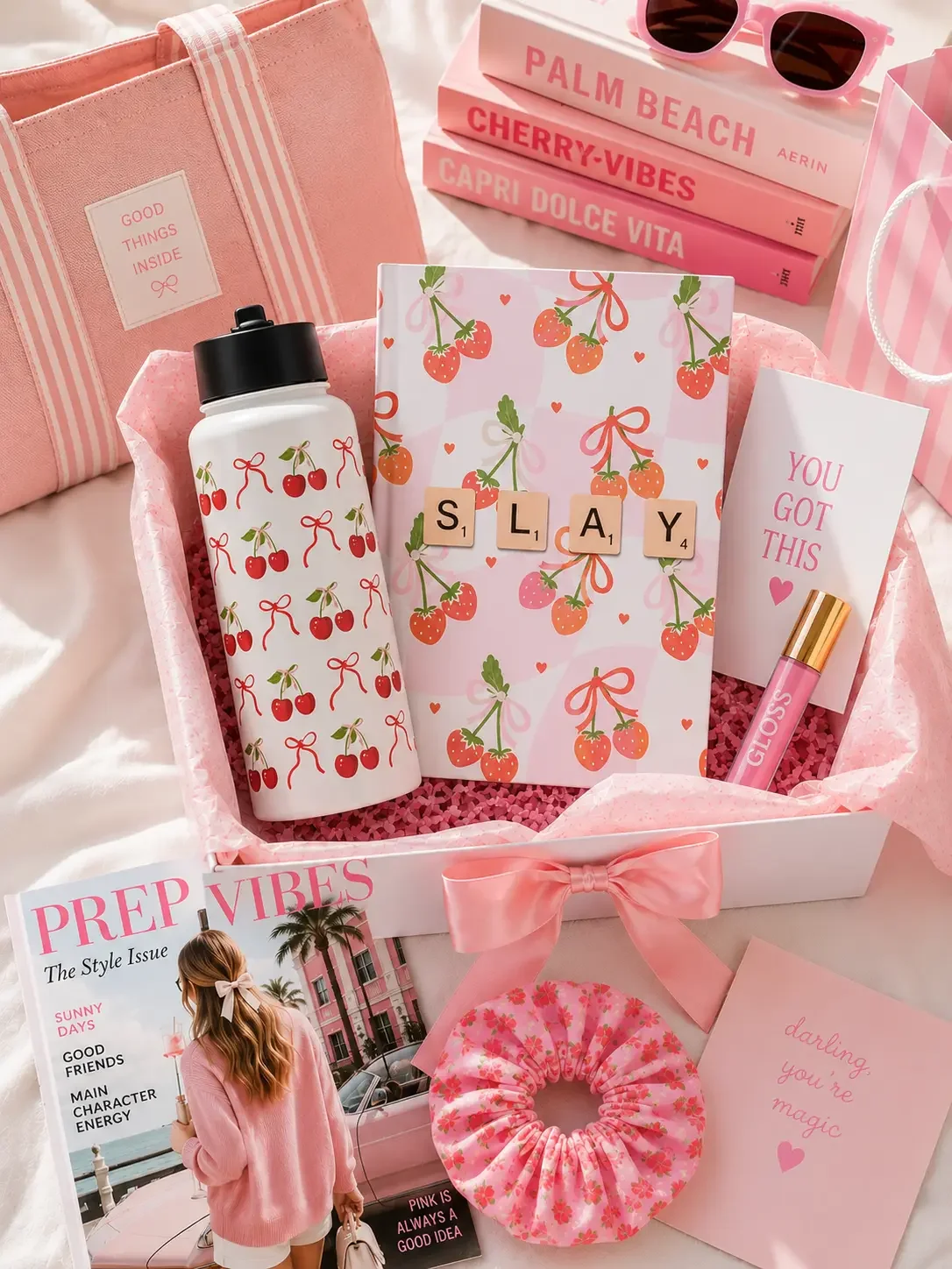 Preppy gift box containing a cherry print water bottle, strawberry patterned notebook, pink scrunchie, and decorative books.