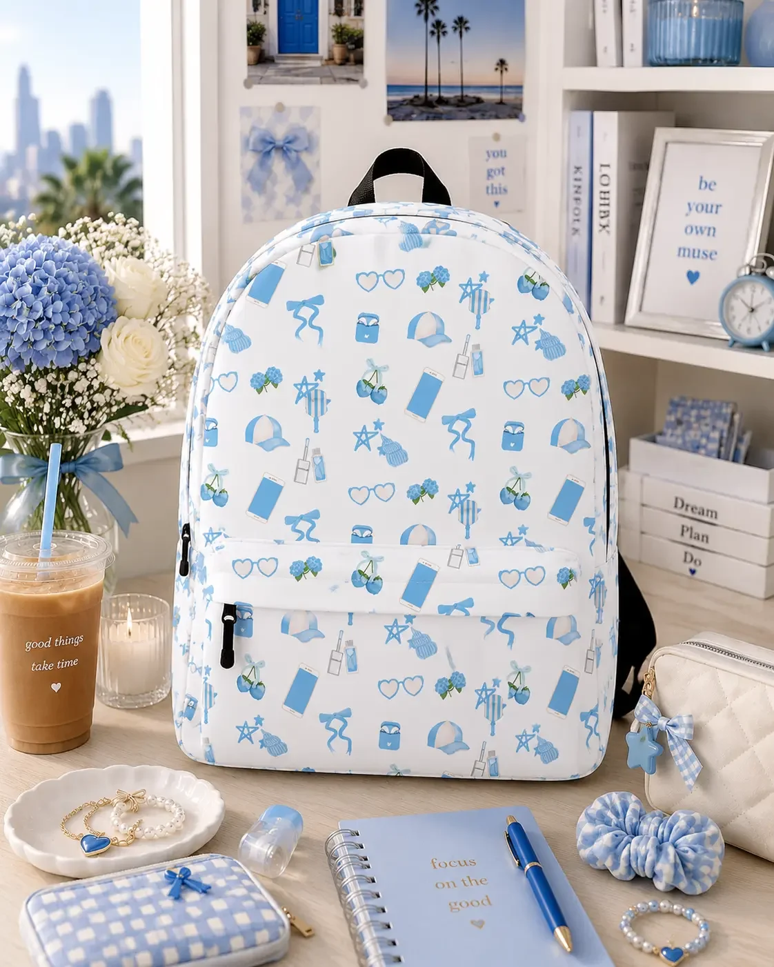 White backpack featuring a light blue preppy icon pattern stands on a desk styled with matching blue stationery.