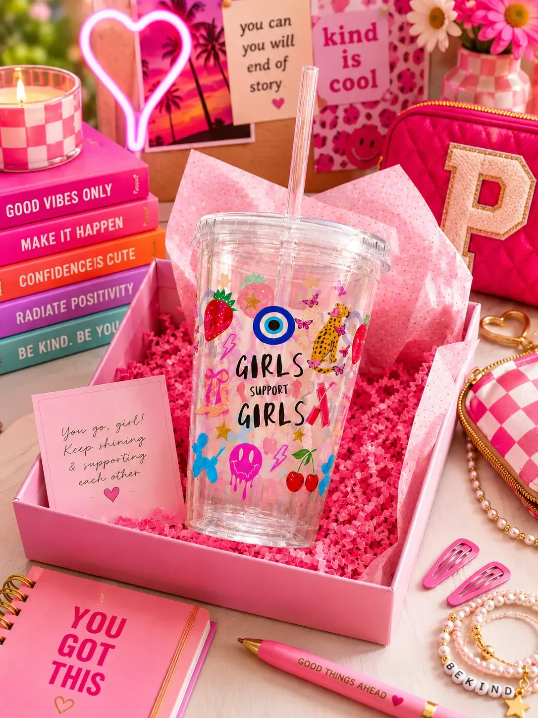 A preppy "Girls Support Girls" doodle tumbler cup inside a pink gift box next to motivational note cards and accessories.