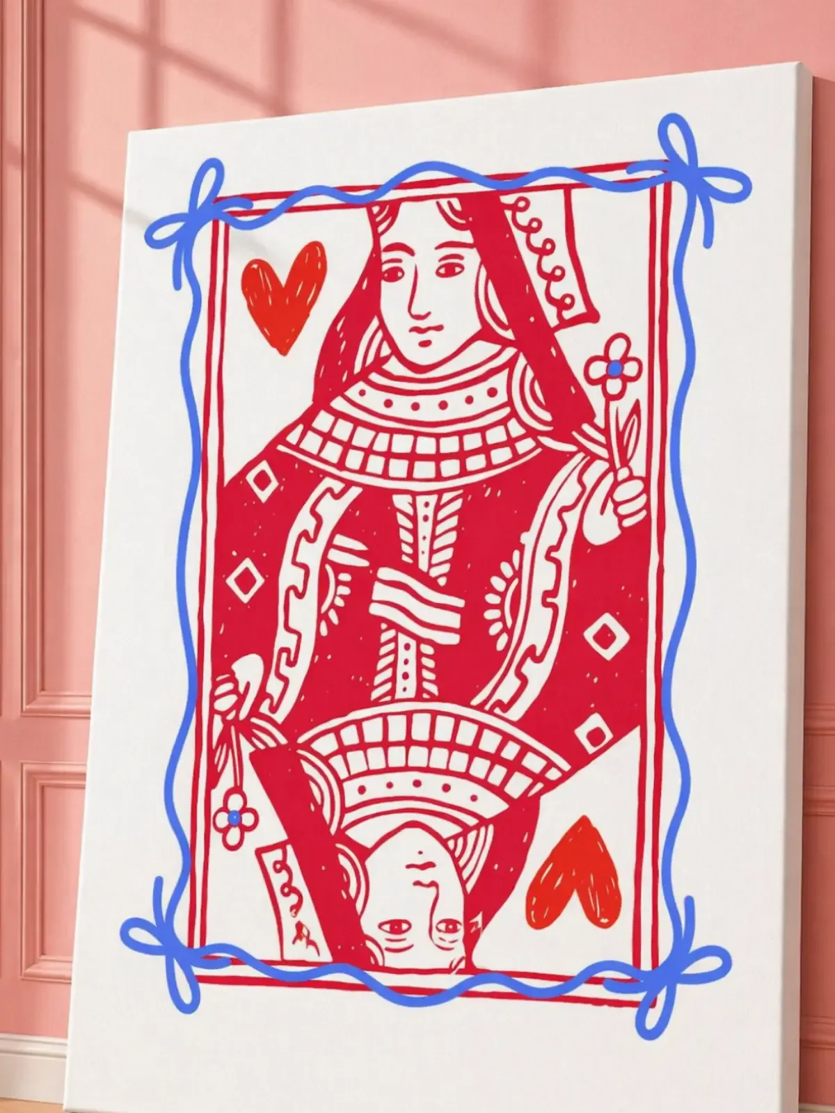 An angled close-up view of a vertical white canvas displaying a red Queen of Hearts graphic with a sketchy blue ribbon border.
