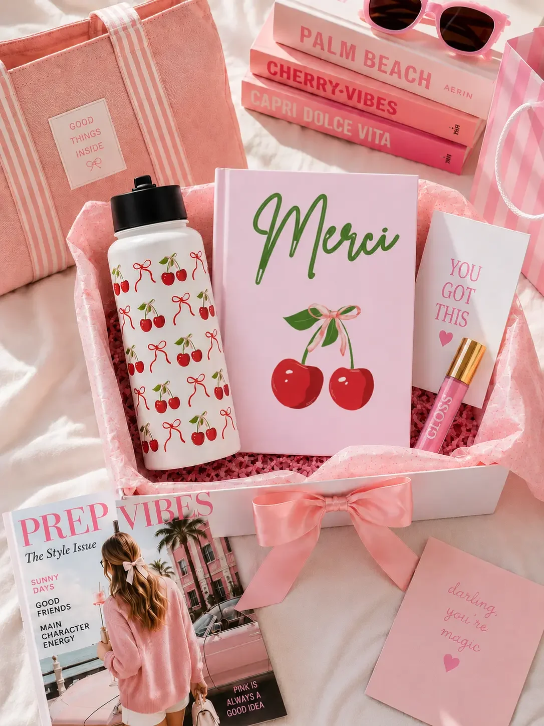 Preppy pink gift box filled with a matching "Merci" cherry journal, cherry pattern water bottle, lip gloss, and aesthetic accessories.