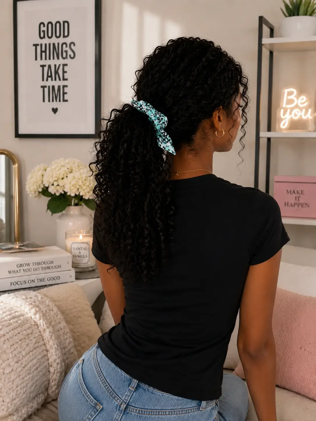 Rear view of a woman with long dark curly hair in a low ponytail secured with a mint green Y2K graffiti star bow scrunchie.