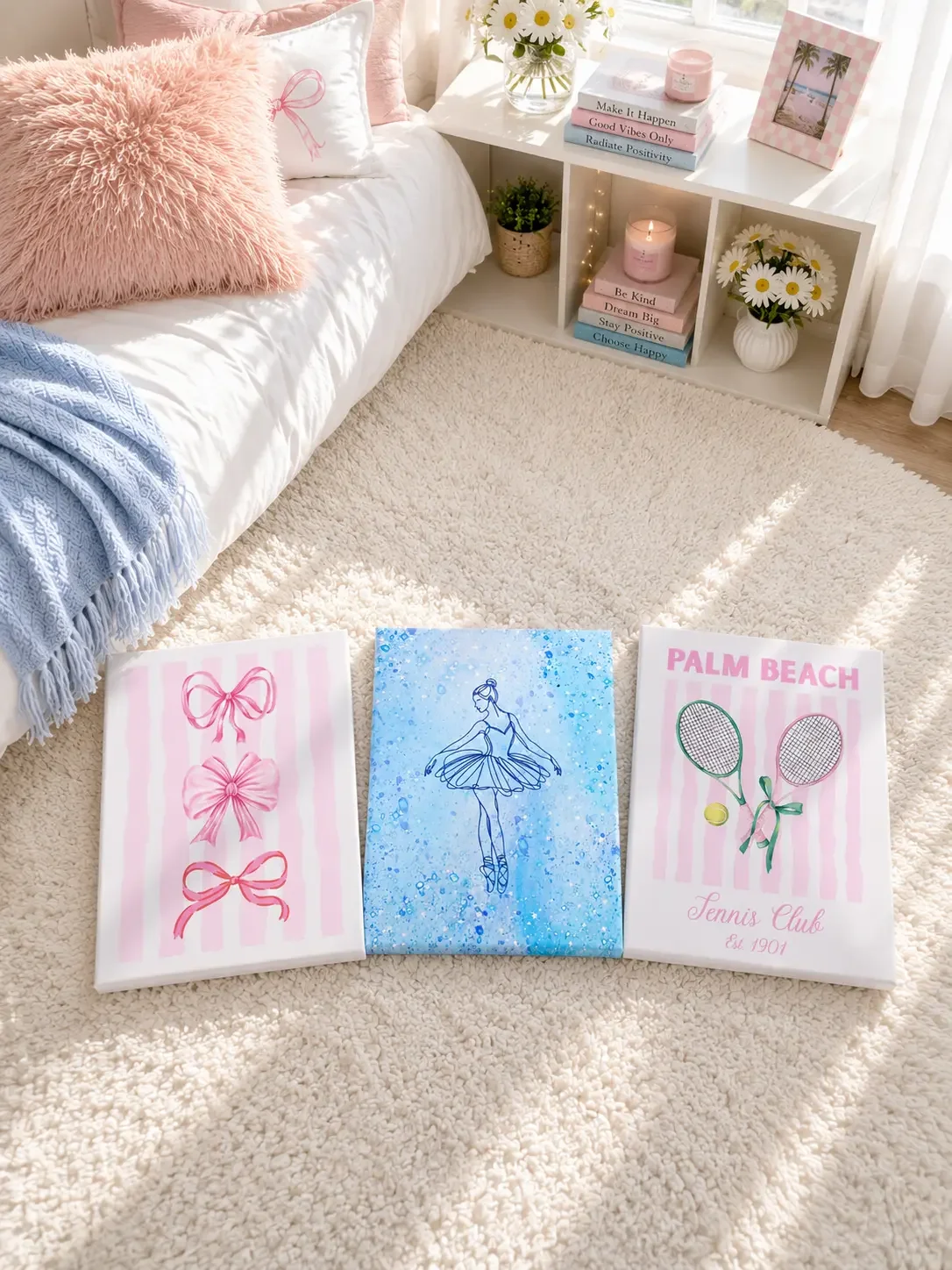 Three canvas prints featuring pink bows, a blue ballerina, and a Palm Beach tennis racket design on a white rug.