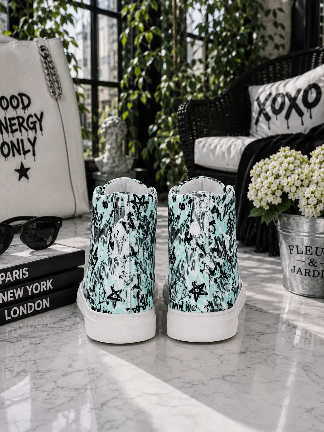 Back heel view of mint green graffiti print high-top canvas sneakers on a marble table with edgy city street aesthetic decor.