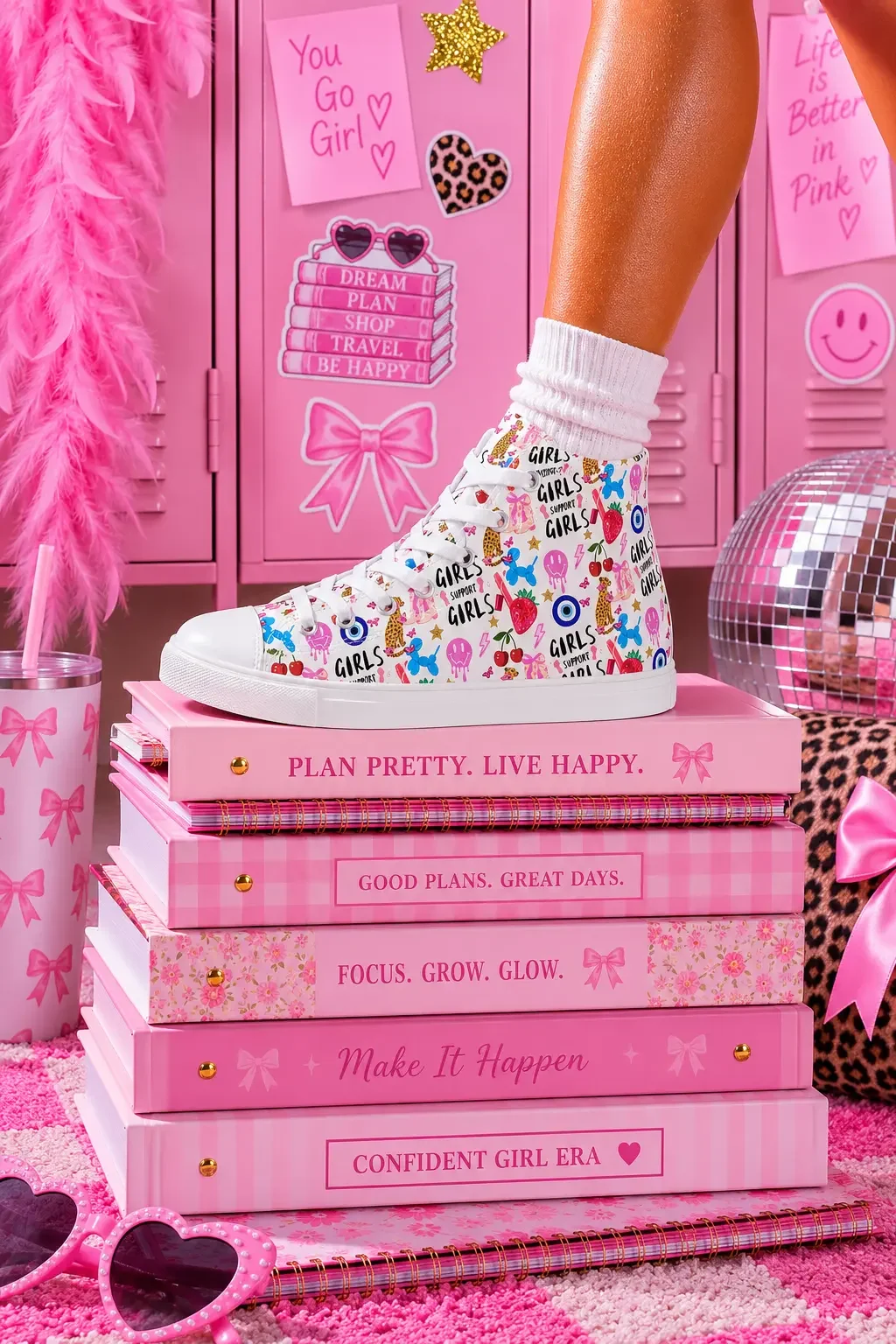 A person wearing white graphic high-top canvas sneakers standing on top of a stack of pink preppy journals by pink school lockers.