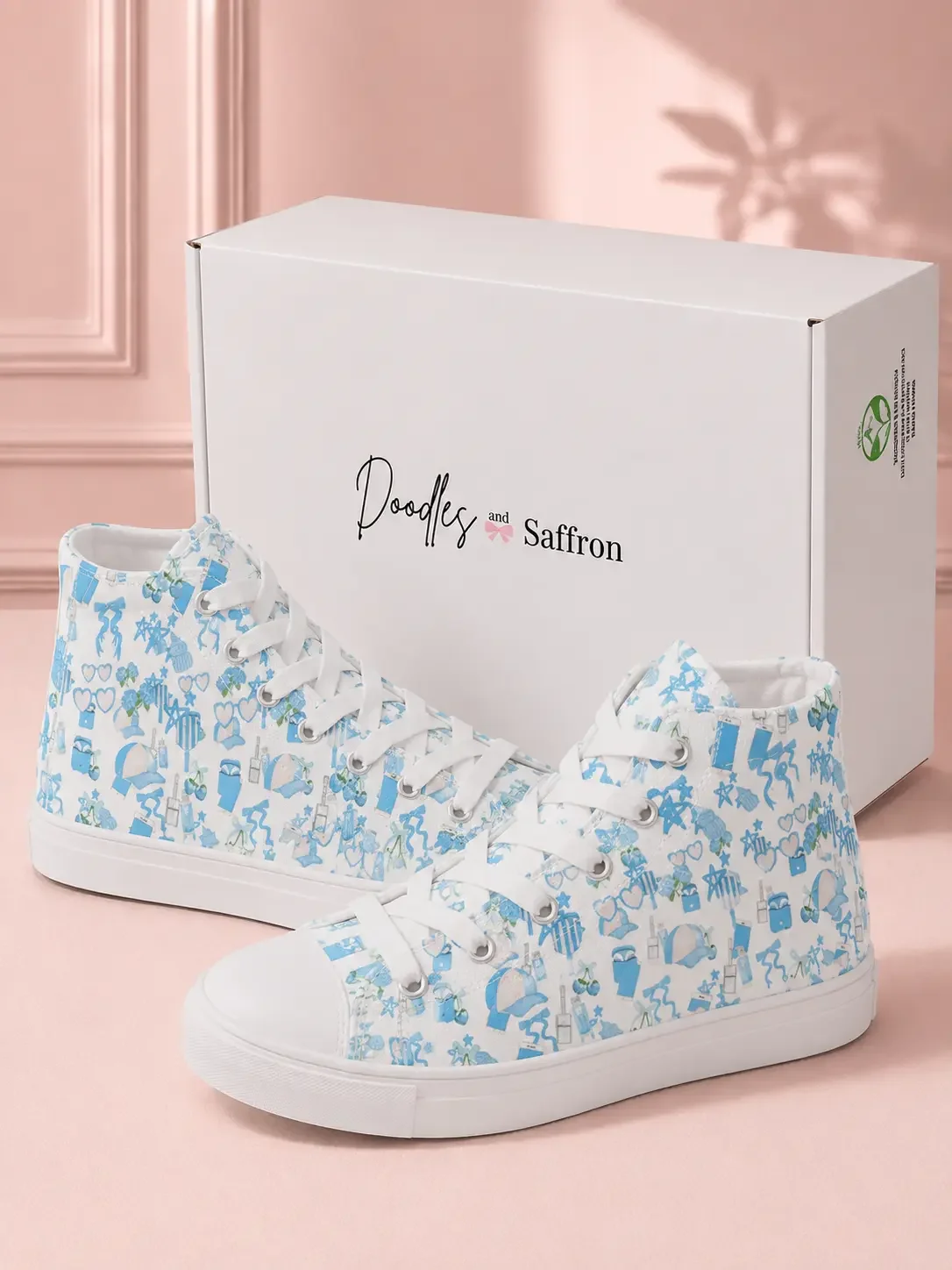 A pair of blue coastal charm print high-top canvas sneakers displayed in front of a white Doodles and Saffron shoebox.