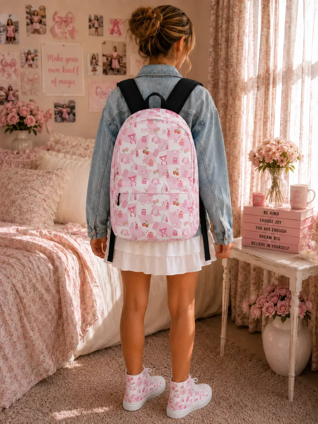 A woman from behind wearing a denim jacket and white skirt, carrying a pink and white checkered backpack with cute doodle illustrations and wearing matching high-top shoes.