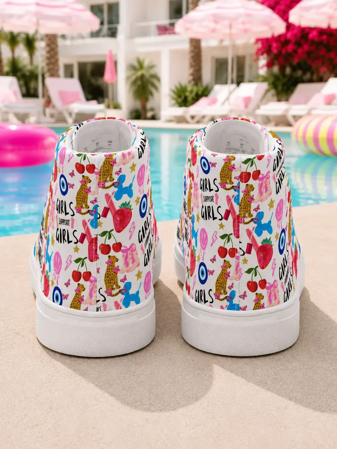 Back heel angle of white graphic high-top canvas sneakers featuring a colorful doodle pattern next to a resort pool.