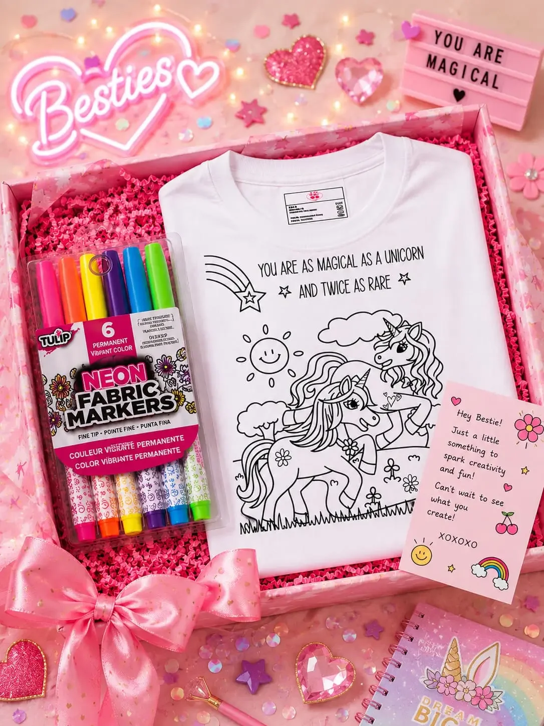 Open pink gift box featuring a white unicorn coloring shirt, Tulip fabric markers, and a bestie gift card.