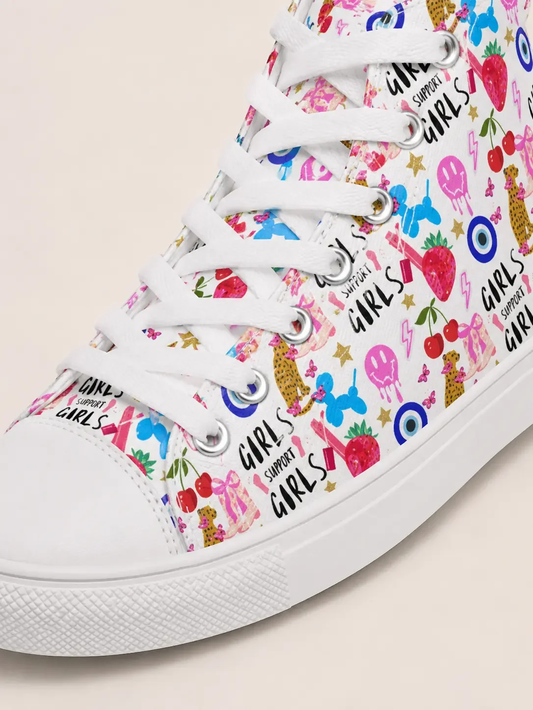 Close-up detail of white shoelaces, eyelets, and a canvas material featuring a colorful Girls Support Girls doodle print pattern.