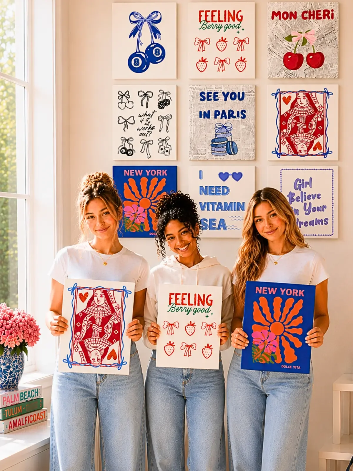 Three young women hold canvas prints in front of a nine-piece preppy coquette aesthetic bedroom gallery wall.
