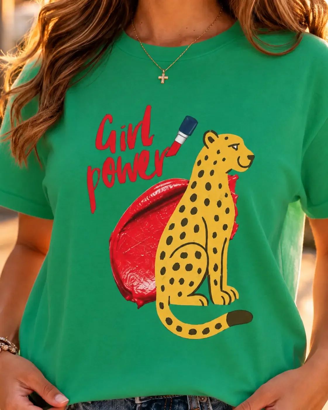 Close-up view of a green crew neck t-shirt featuring a red lipstick swipe and a cartoon cheetah illustration with the text Girl Power.