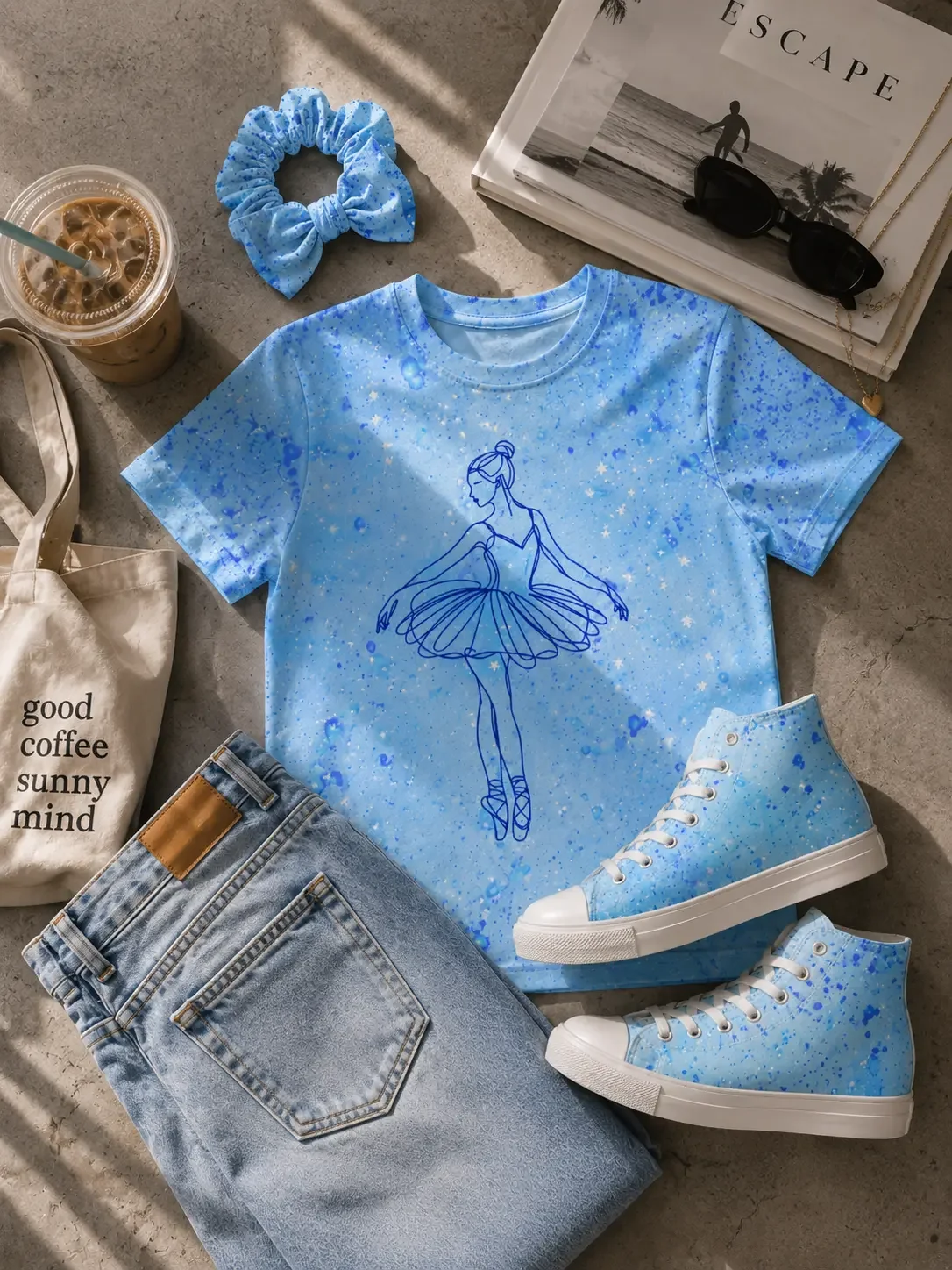 Flat lay of a blue ballerina t-shirt, light wash jeans, matching paint-splattered sneakers, and a scrunchie.