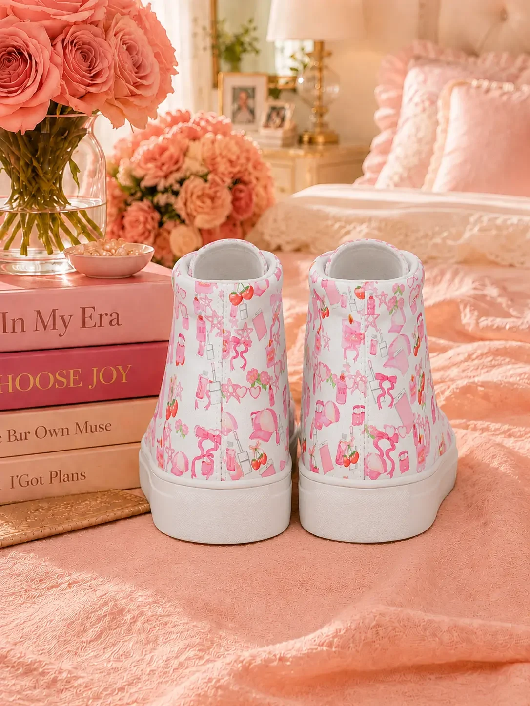 Back heel view of a pair of white high-top canvas sneakers with a pink doodle print pattern sitting on a pink bed.