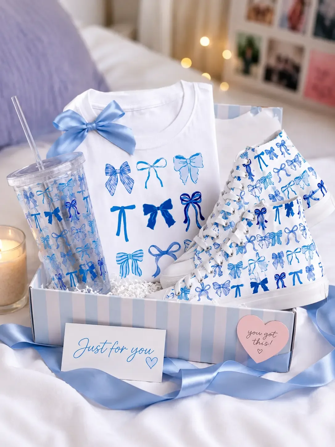 Open striped gift box containing a white blue-bow graphic t-shirt, matching patterned sneakers, and an acrylic tumbler (Copy)