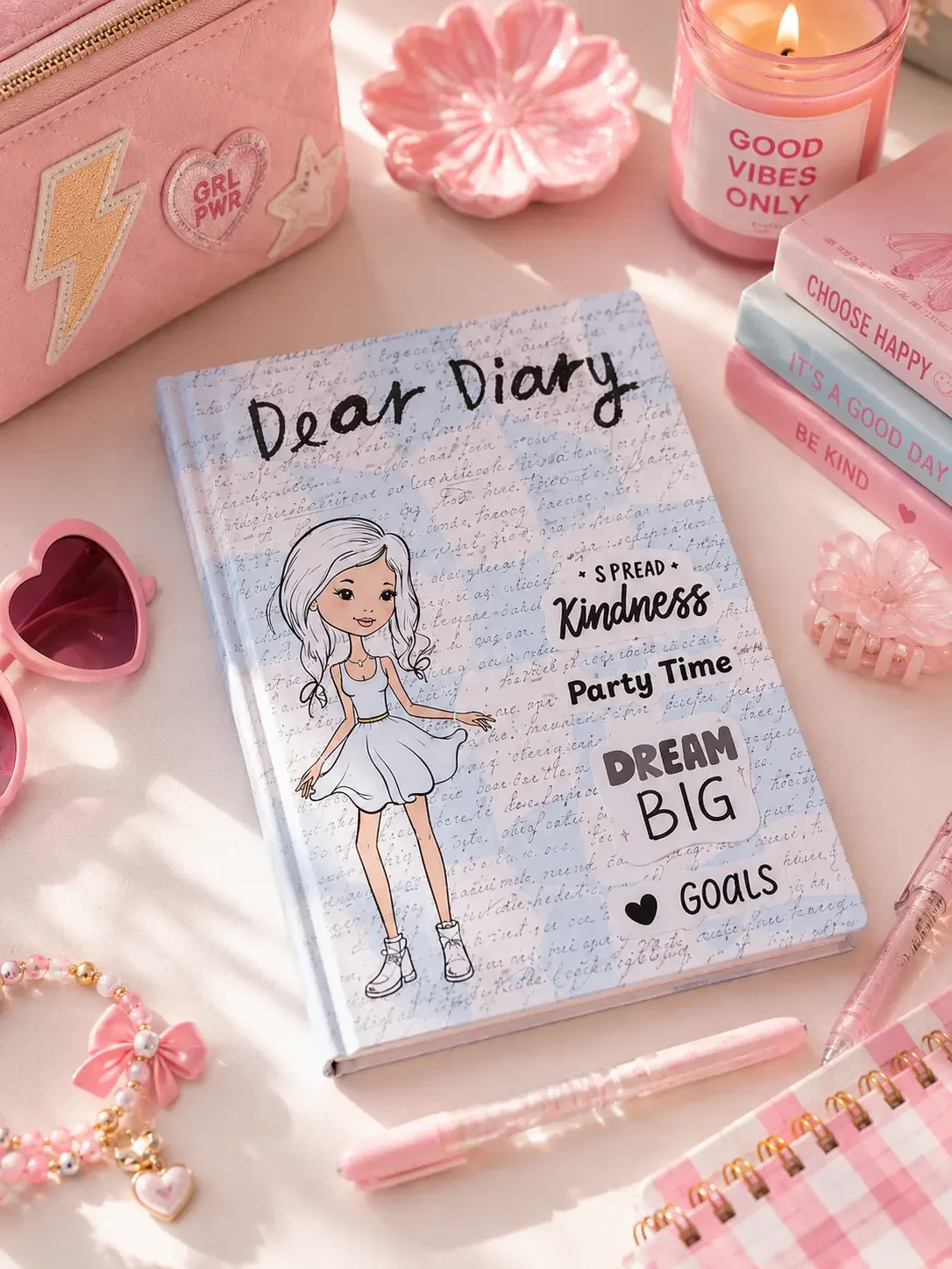 Light blue "Dear Diary" notebook with a coquette fashion girl illustration, styled on an aesthetic pink desk setup.
